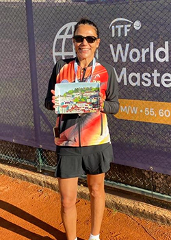 Tennisspielerin Alice Schöpp vom SC Rot-Weiß Remscheid hält einen Pokal vor dem Banner der ITF World Tennis Masters Tour.
